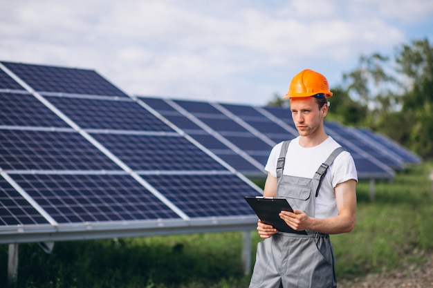 Hombre trabajador en el campo junto a los paneles solares.