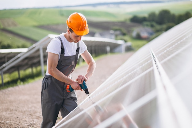 Foto gratuita hombre trabajador en el campo junto a los paneles solares.