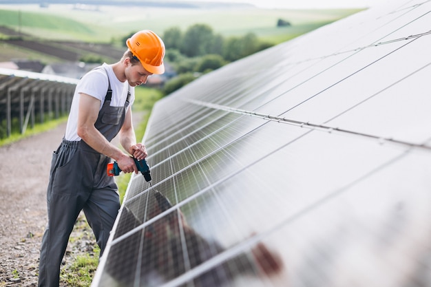 Hombre trabajador en el campo junto a los paneles solares.