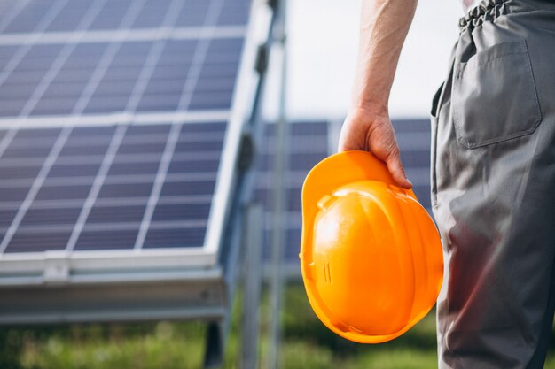 Hombre trabajador en el campo junto a los paneles solares.