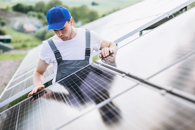 Hombre trabajador en el campo junto a los paneles solares.