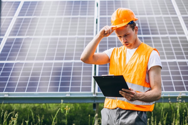 Hombre trabajador en el campo junto a los paneles solares.