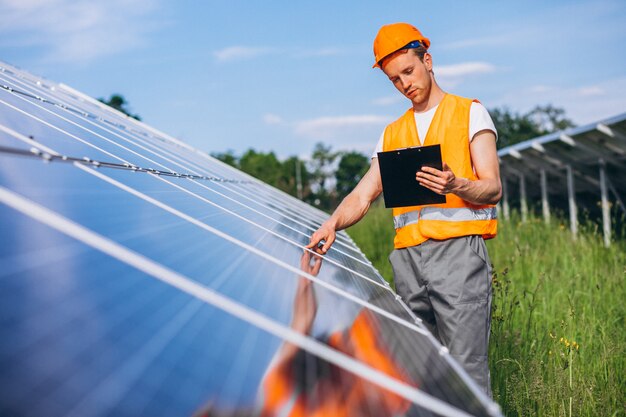 Hombre trabajador en el campo junto a los paneles solares.