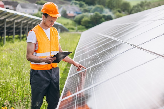 Hombre trabajador en el campo junto a los paneles solares.