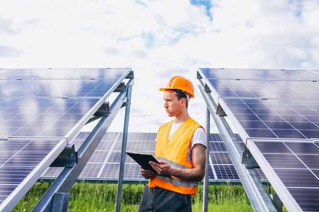 Hombre trabajador en el campo junto a los paneles solares.