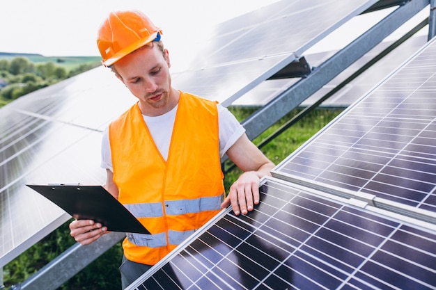 Hombre trabajador en el campo junto a los paneles solares.