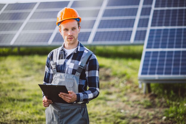 Hombre trabajador en el campo junto a los paneles solares.