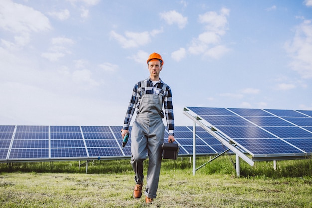 Hombre trabajador en el campo junto a los paneles solares.