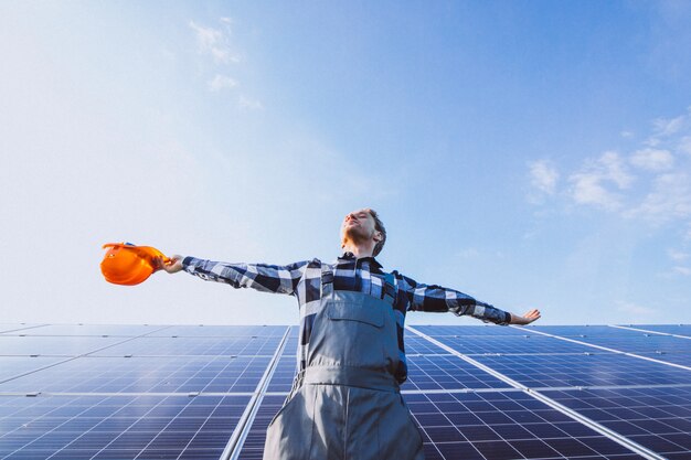 Hombre trabajador en el campo junto a los paneles solares.