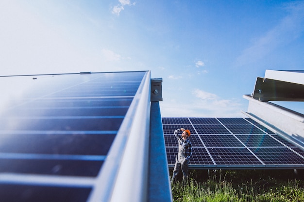 Hombre trabajador en el campo junto a los paneles solares.