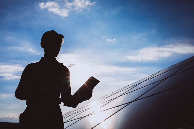 Hombre trabajador en el campo junto a los paneles solares.