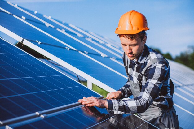 Hombre trabajador en el campo junto a los paneles solares.