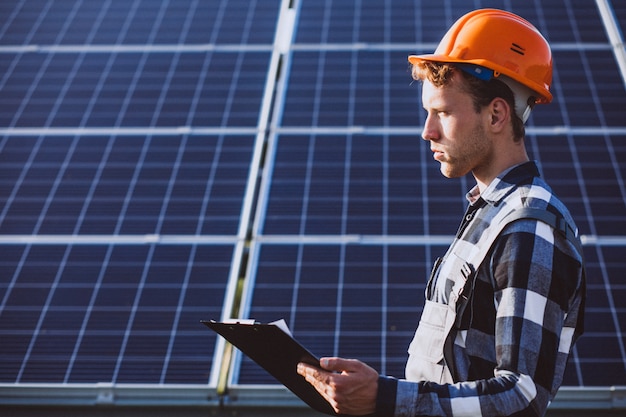 Hombre trabajador en el campo junto a los paneles solares.