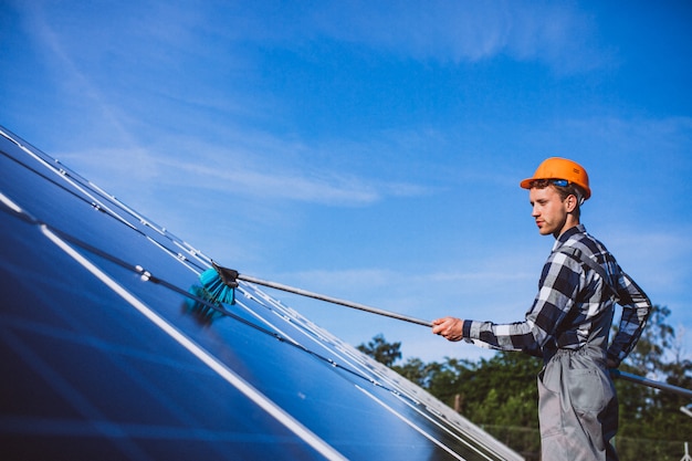 Hombre trabajador en el campo junto a los paneles solares.