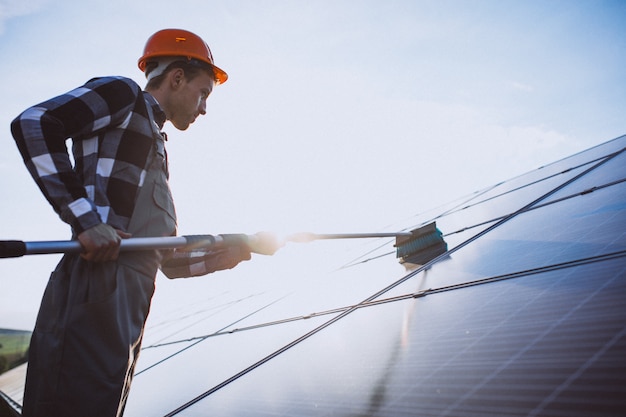 Hombre trabajador en el campo junto a los paneles solares.