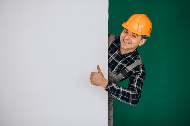 Hombre trabajador en casco aislado en pared verde