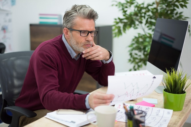 Hombre trabajador leyendo algunos documentos importantes