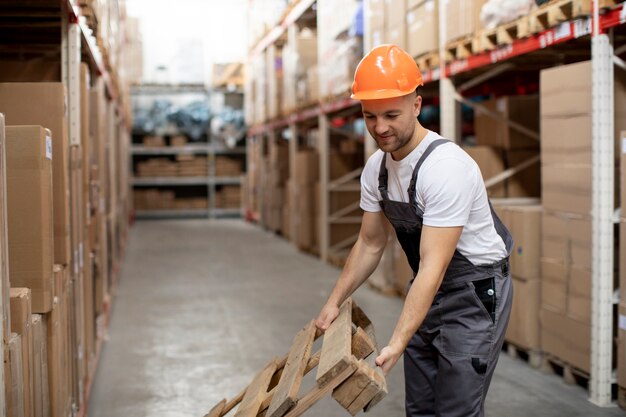 Hombre trabajando en almacén plano medio