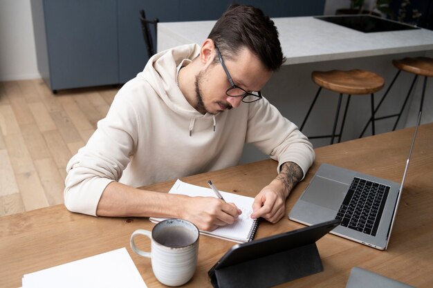 Hombre trabajando desde casa en un escritorio con un portátil