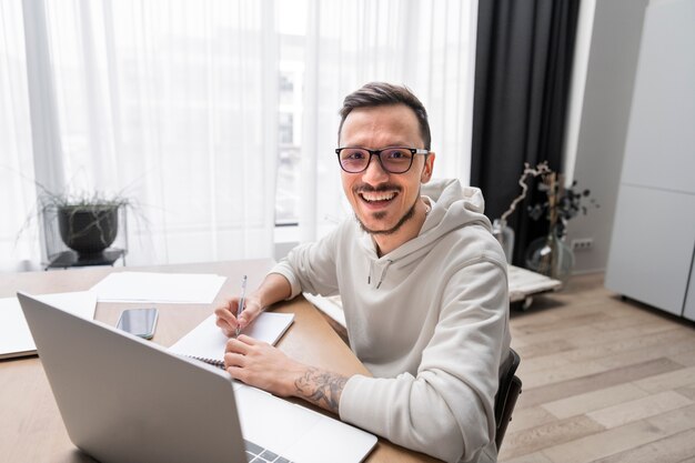 Hombre trabajando desde casa en un escritorio con un portátil