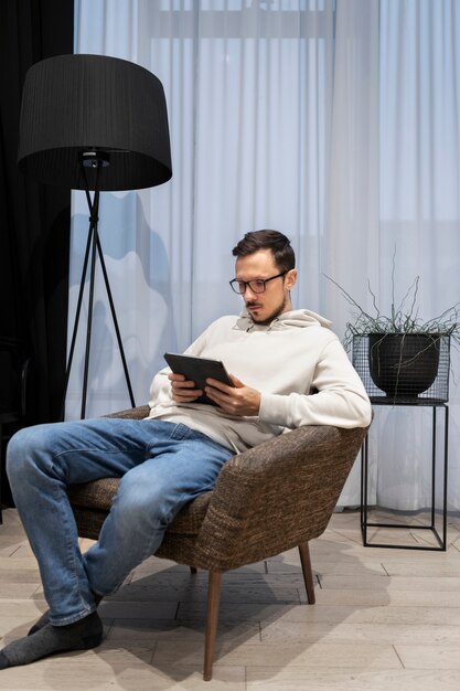 Hombre trabajando desde casa sentado en un sillón