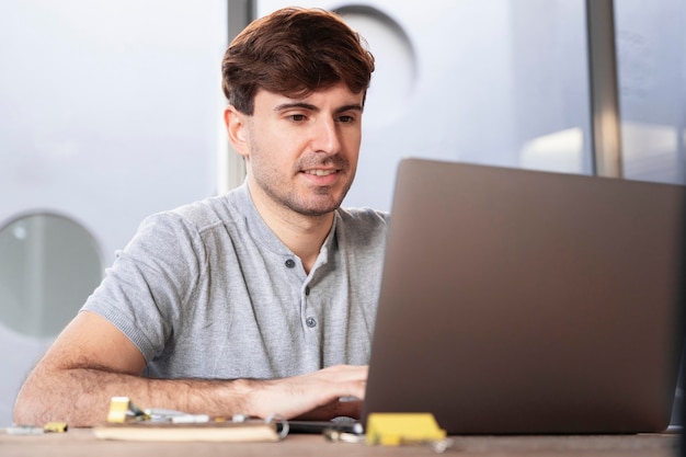 Hombre trabajando como autónomo en casa en su computadora portátil