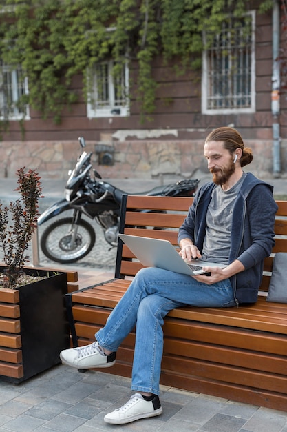 Hombre trabajando en la computadora portátil en la ciudad