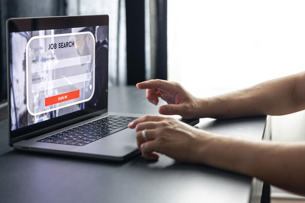 Hombre trabajando en una computadora portátil e información para el concepto de búsqueda de empleo