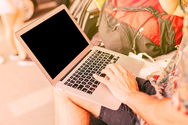 Hombre trabajando en una computadora portátil mientras viaja