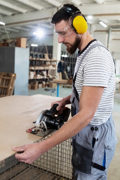 Foto gratuita hombre trabajando en cortar tablero mdf