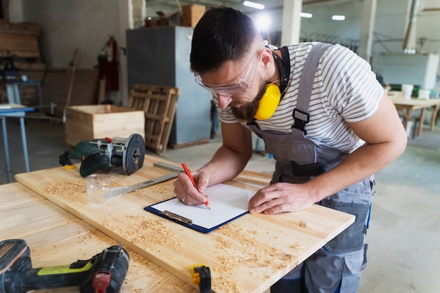 Foto gratuita hombre trabajando en cortar tablero mdf