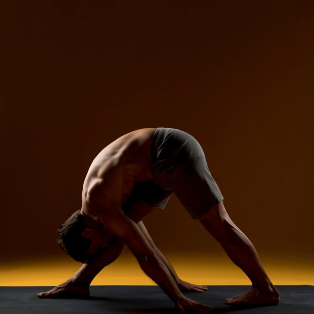 Hombre trabajando en estera de yoga