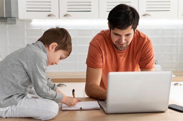 Hombre trabajando de forma remota con kid