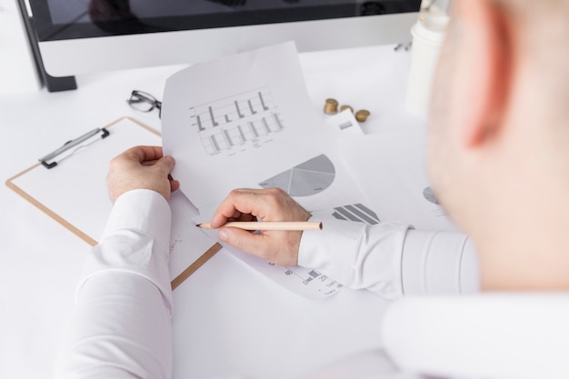 Hombre trabajando en gráficos en su escritorio de negocios