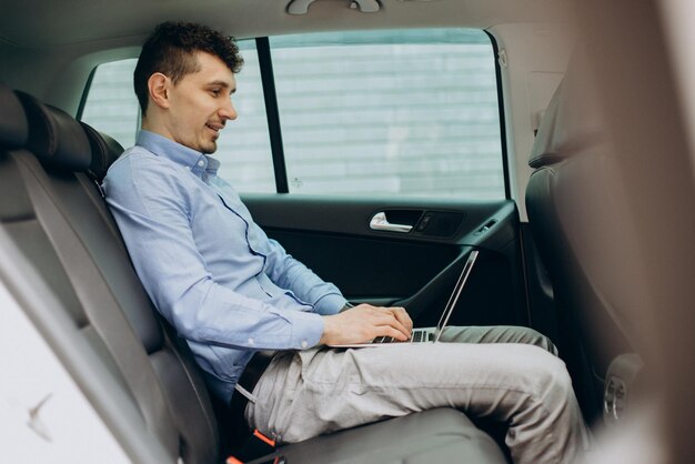 Hombre trabajando en una laptop dentro de su auto