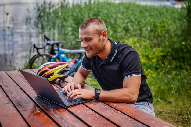 Hombre trabajando con una laptop en la mesa sobre la naturaleza.