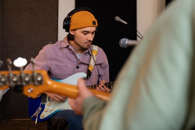 Foto gratuita hombre trabajando en música en estudio con instrumentos.