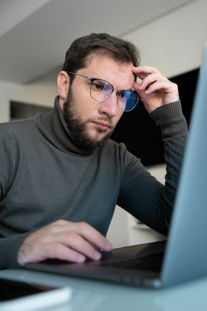 Hombre trabajando en un portátil de tiro medio