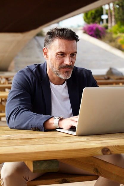 Hombre trabajando con su computadora al aire libre