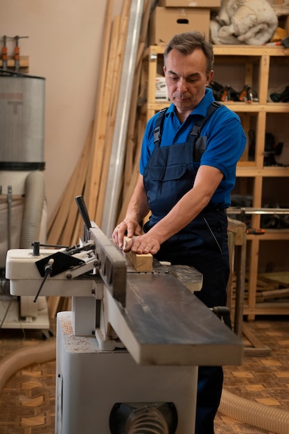 Hombre trabajando en su taller de carpintería con herramientas y equipos.