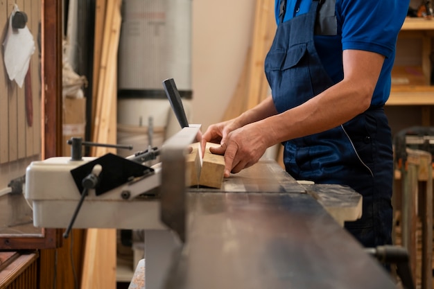 Foto gratuita hombre trabajando en su taller de carpintería con herramientas y equipos.