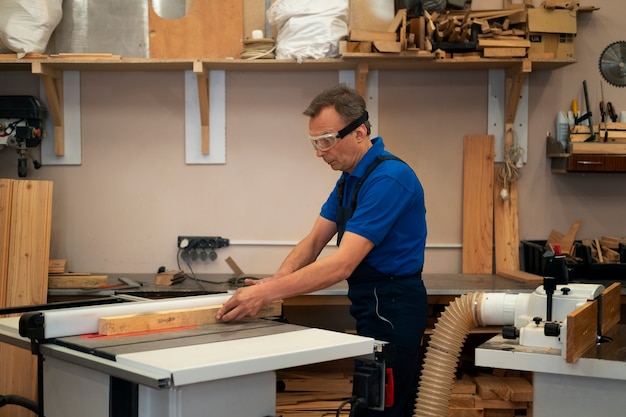 Foto gratuita hombre trabajando en su taller de carpintería con herramientas y equipos.