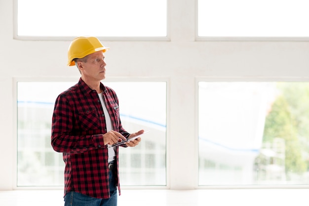 Foto gratuita hombre trabajando en tableta con espacio de copia