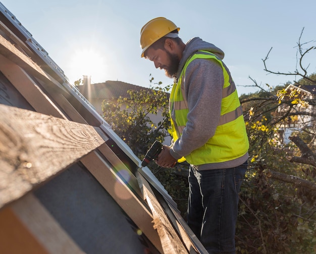 Foto gratuita hombre trabajando en el techo con un taladro