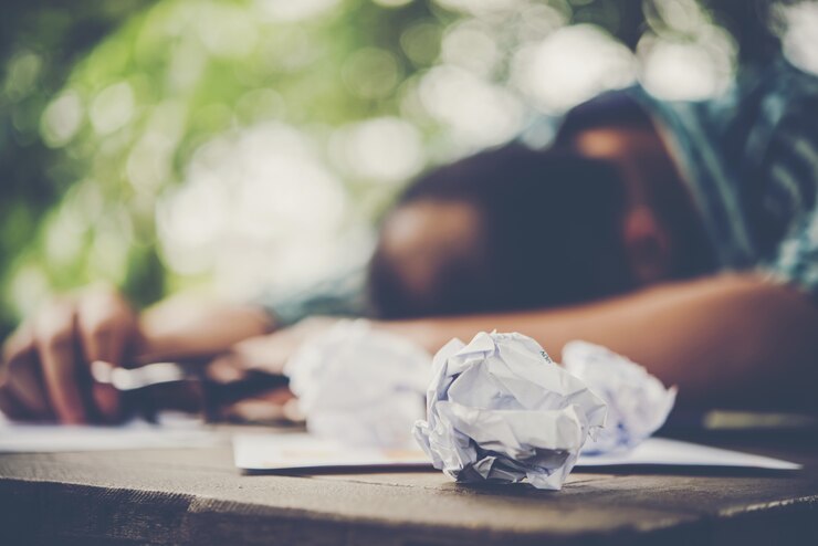 Foto gratuito hombre de trabajo cansado durmiendo en el lugar de trabajo lleno de trabajo.