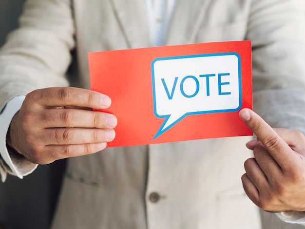 Hombre en traje apuntando a un mensaje de votación