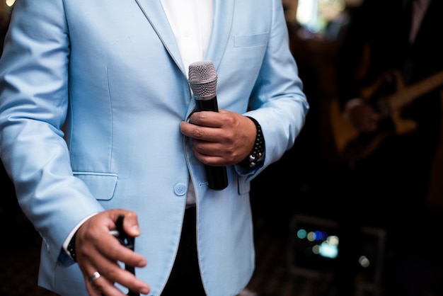 El hombre en traje azul tiene un micrófono