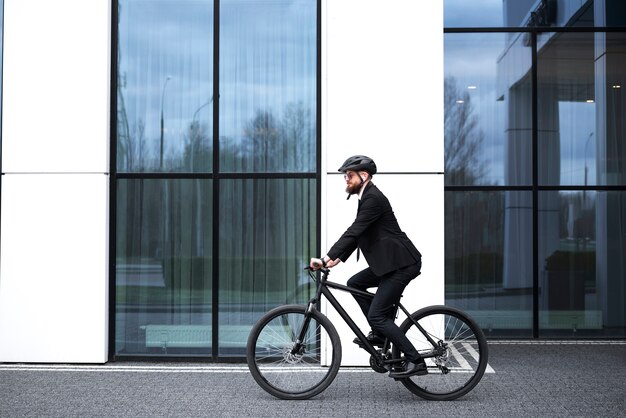 Hombre en traje de ciclismo al trabajo vista lateral