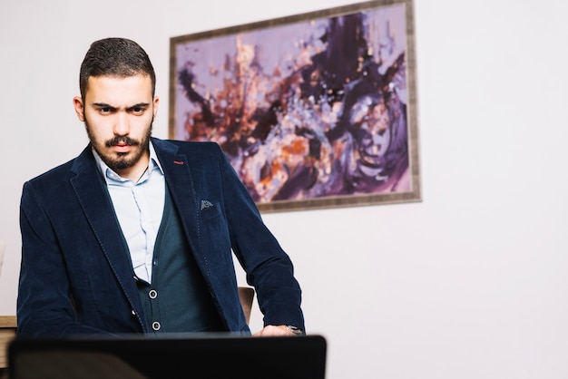 Hombre en traje en la computadora portátil