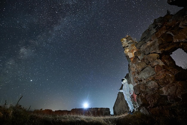 El hombre en traje espacial camina en un área abandonada